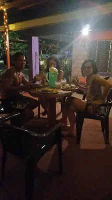 a group of three people sitting at a table at Passiflora Backpackers Samara in Sámara