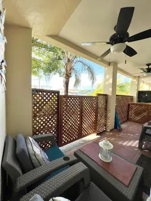 a patio with a ceiling fan and chairs and a table at The Castaway in Coco