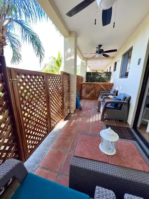 an outdoor patio with chairs and a ceiling fan at The Castaway in Coco