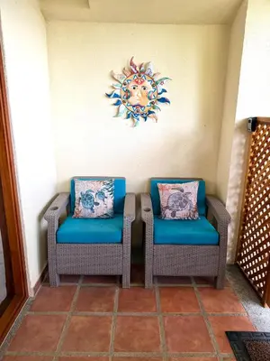 two chairs with blue cushions sitting next to a wall at The Castaway in Coco