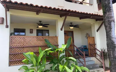 a house with a porch with two ceiling fans at The Castaway in Coco