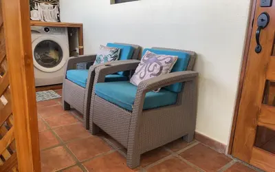 two wicker chairs with pillows sitting next to a washing machine at The Castaway in Coco