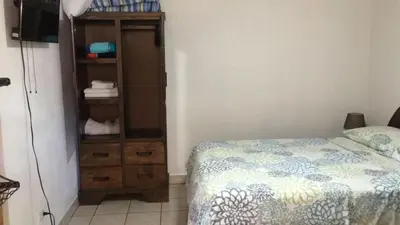 a bedroom with a bed and a wooden dresser at Casa Flores Carrillo - Monkey Cabena in Carrillo