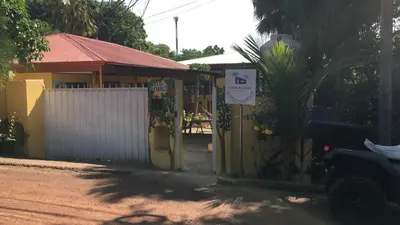 a building with a gate with a sign on it at Casa Flores Carrillo - Monkey Cabena in Carrillo