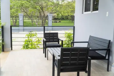 two black benches sitting on a balcony with a view at Condominios Akira in Tamarindo