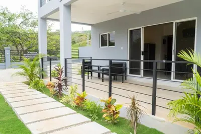 a balcony of a house with benches and plants at Condominios Akira in Tamarindo