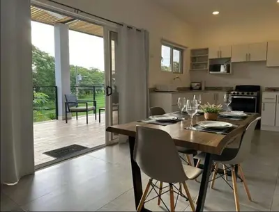 a kitchen and dining room with a wooden table and chairs at Condominios Akira in Tamarindo