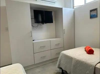 a bedroom with a bed and a tv on a wall at Condominios Akira in Tamarindo