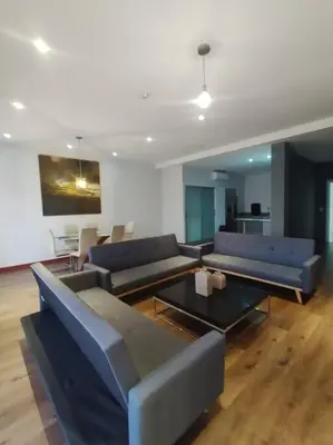 a living room with blue couches and a table at Jaco Bay Condo with Great Views! in Jacó