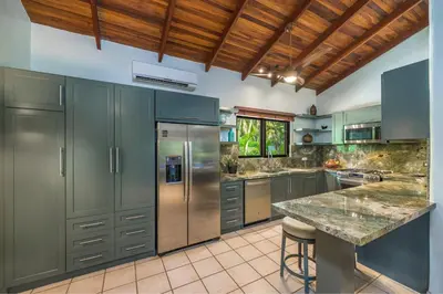 a kitchen with stainless steel appliances and a wooden ceiling at Tropical Retreat - Private Pool, Steps to Beach in Tamarindo