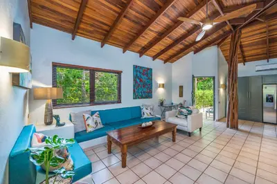 a living room with a blue couch and a wooden ceiling at Tropical Retreat - Private Pool, Steps to Beach in Tamarindo