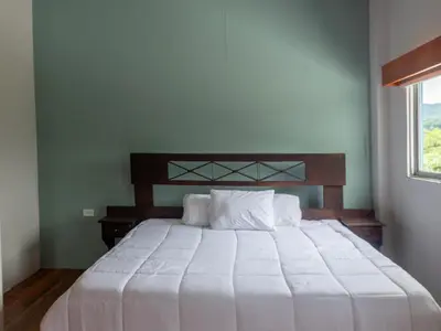 a white bed in a room with a window at Organic Garden in San José