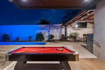 a pool table in a backyard at night at La Casa de Papi. in Parrita