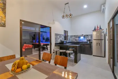 a kitchen with a table with a bowl of fruit at La Casa de Papi. in Parrita