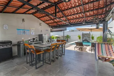 an outdoor kitchen with a table and chairs at La Casa de Papi. in Parrita