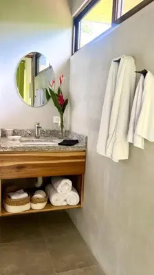 a bathroom with a sink and a mirror and towels at Sharma Costa Rica- Mimosa Casita in Uvita