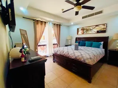 a bedroom with a bed and a ceiling fan at Apartamento de Lujo en Playa Jacó, Frente al Mar, Wifi, AC, Parqueo Privado y Piscinas in Jacó