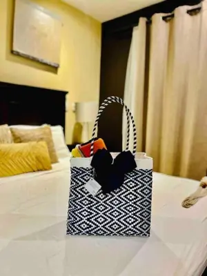 a black and white bag sitting on top of a bed at Apartamento de Lujo en Playa Jacó, Frente al Mar, Wifi, AC, Parqueo Privado y Piscinas in Jacó