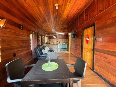 a dining table and chairs in a room with wooden walls at Chalet El Riachuelo in La Suiza