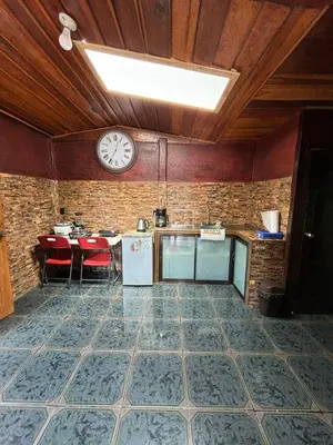 a kitchen with a clock on the wall and a table at Chalet El Riachuelo in La Suiza