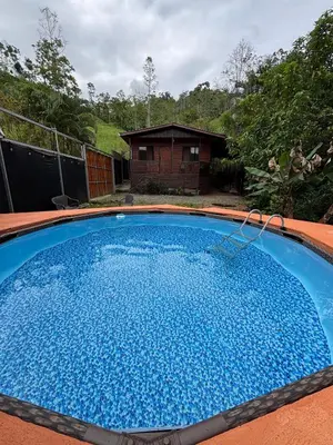 a large blue swimming pool in front of a house at Chalet El Riachuelo in La Suiza