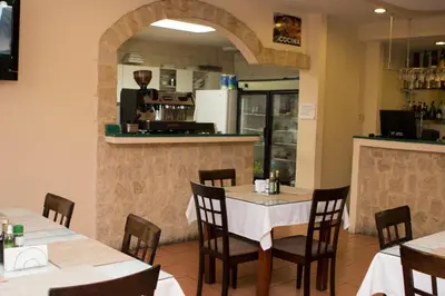 a restaurant with tables and chairs and a counter at Hotel Novo in San José