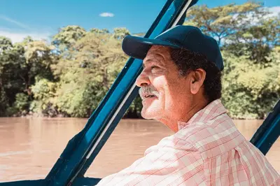 a man wearing a hat looking out the window of a river at Condo La Perla 163, Ocean View 3 Bedroom Penthouse in Tamarindo