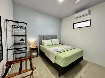 a bedroom with a bed and a book shelf at Oasis Arenal Villa Downtown Arenal Volcano View in Fortuna