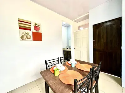 a dining room with a wooden table and chairs at Oasis Arenal Villa Downtown Arenal Volcano View in Fortuna