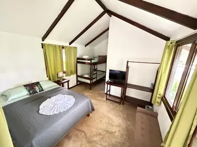 a bedroom with a bed and a television in it at Casa y Cabaña Jaguar Tortuguero in Tortuguero