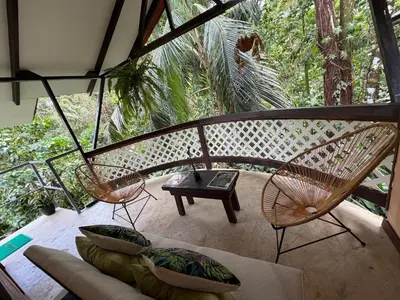 a living room with two chairs and a couch at Casa y Cabaña Jaguar Tortuguero in Tortuguero