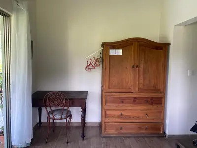 a room with a wooden desk and a wooden cabinet at Apartamento con Terraza y Vista al Jardín in Uvita