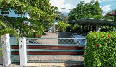 a gate to a driveway in front of a house at Apartamento con Terraza y Vista al Jardín in Uvita