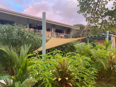 a hammock in a garden in front of a house at Apartamento con Terraza y Vista al Jardín in Uvita