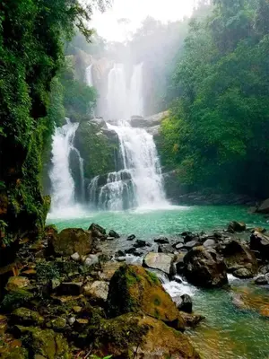 a waterfall in the middle of a river with rocks at Apartamento con Terraza y Vista al Jardín in Uvita