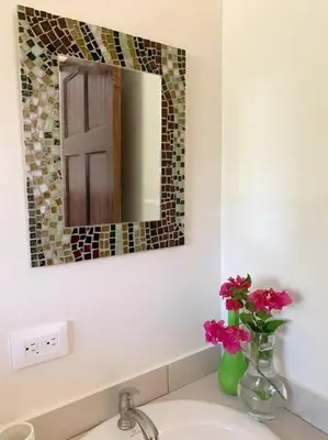 a bathroom sink with a vase with flowers on it at Beautiful studio-apartment near the beach in Uvita