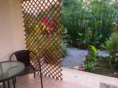 a garden with a fence and a table and chairs at Beautiful studio-apartment near the beach in Uvita