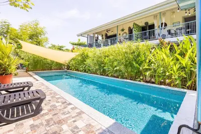 a swimming pool in front of a house at Beautiful studio-apartment near the beach in Uvita