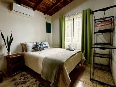 a bedroom with a bed with a green curtain at Cabañas Litos #2 in Fortuna