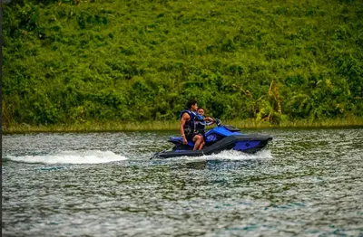 a man and a boy on a jet ski in the water at Cabañas Litos #2 in Fortuna