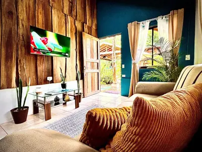 a living room with a couch and a flat screen tv at Cabañas Litos #2 in Fortuna