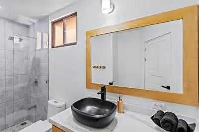 a bathroom with a black sink and a mirror at Modern Split-Level 2-Bedroom Condo with Pools, Terrace & Easy Beach Access in Coco