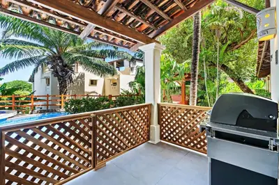 a kitchen with an outdoor grill on a wooden deck at Modern Split-Level 2-Bedroom Condo with Pools, Terrace & Easy Beach Access in Coco