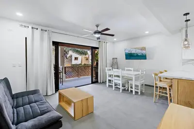 a living room with a couch and a table at Modern Split-Level 2-Bedroom Condo with Pools, Terrace & Easy Beach Access in Coco