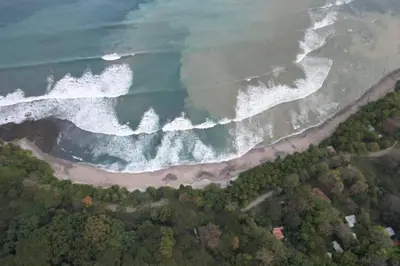 an aerial view of the ocean and a beach at Cabina Playa Cedros in Cóbano