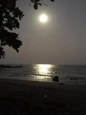 a moon rising over the ocean at the beach at Cabina Playa Cedros in Cóbano