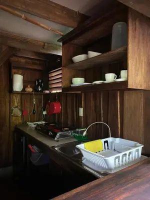 a kitchen counter with a sink and shelves with dishes at Cabina Playa Cedros in Cóbano