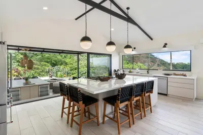 a kitchen with a large white table and chairs at Luxe Tropical Villa with Sparkling Infinity Pool, Panoramic Ocean Views & Community Amenities in Playa Flamingo