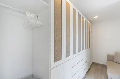 a hallway with white walls and a window at Luxe Tropical Villa with Sparkling Infinity Pool, Panoramic Ocean Views & Community Amenities in Playa Flamingo