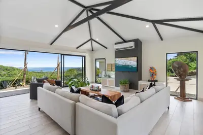 a living room with couches and a table at Luxe Tropical Villa with Sparkling Infinity Pool, Panoramic Ocean Views & Community Amenities in Playa Flamingo